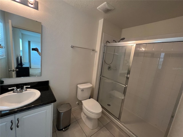 bathroom featuring walk in shower, tile patterned floors, vanity, and toilet