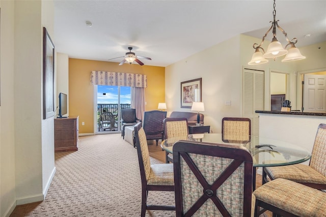 carpeted dining area with ceiling fan