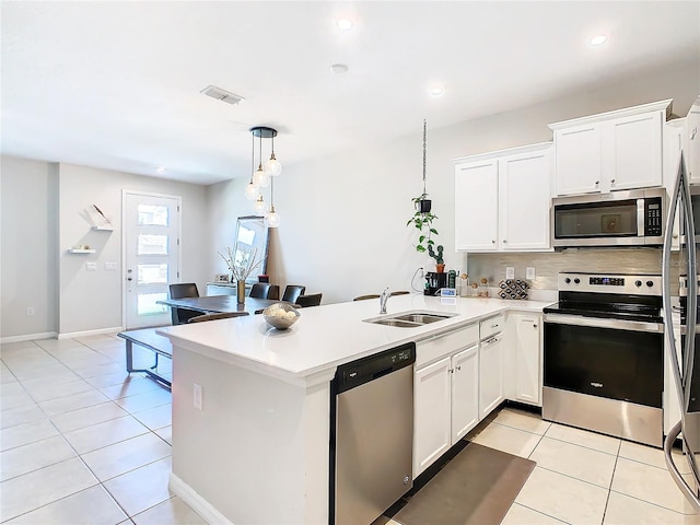 kitchen with white cabinetry, sink, stainless steel appliances, pendant lighting, and light tile patterned flooring