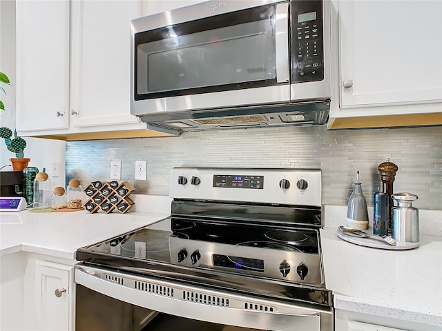 kitchen with backsplash, white cabinets, and stainless steel appliances