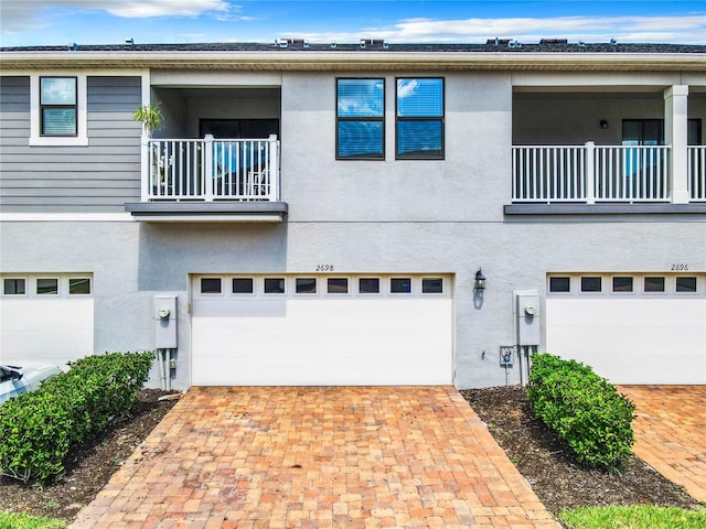 view of front of property featuring a garage and a balcony