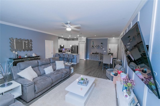 living room featuring ceiling fan, hardwood / wood-style floors, and ornamental molding