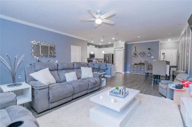 living room with hardwood / wood-style flooring, ceiling fan, and crown molding