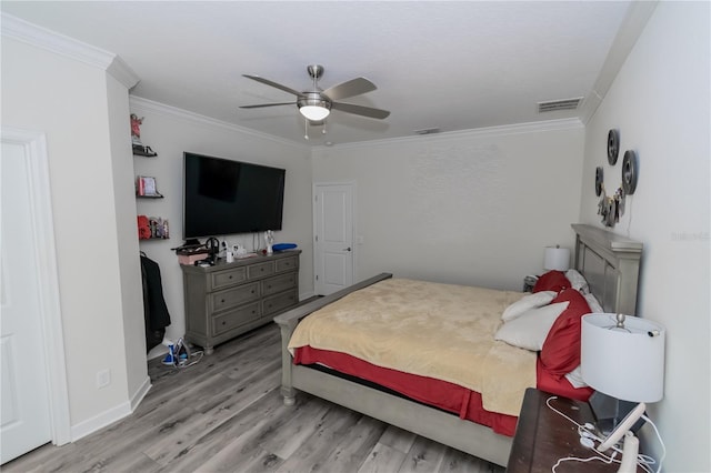 bedroom with ceiling fan, ornamental molding, and wood-type flooring