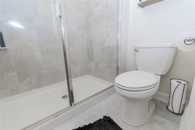 bathroom featuring tile floors, a shower with shower door, and toilet