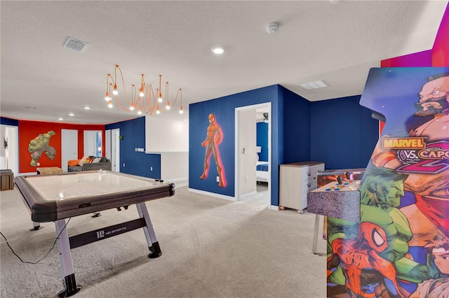 recreation room featuring light colored carpet and a textured ceiling