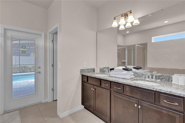 bathroom with walk in shower, vanity, tile patterned flooring, and a chandelier