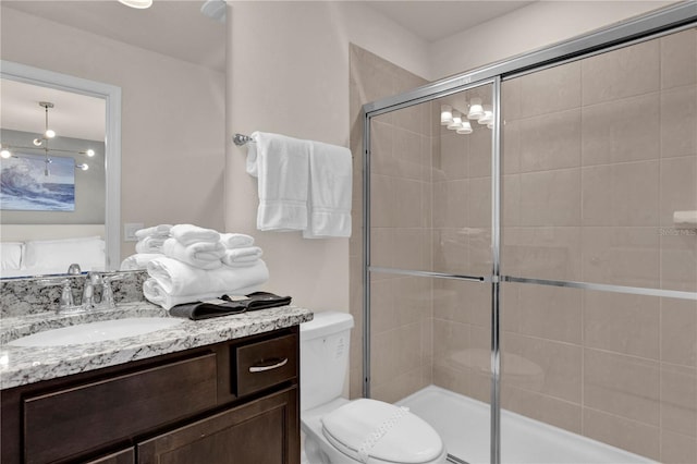 bathroom featuring toilet, an enclosed shower, and vanity