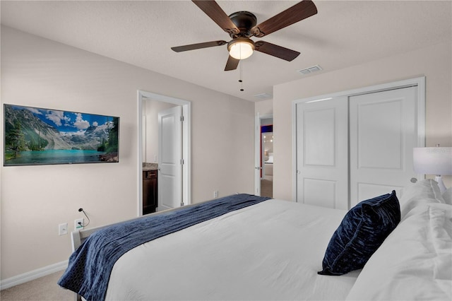 carpeted bedroom with ceiling fan, a textured ceiling, and a closet