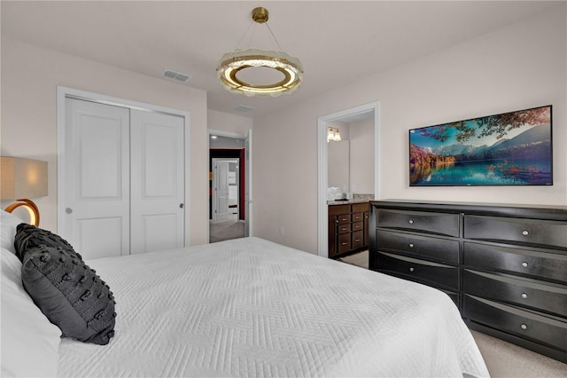 carpeted bedroom featuring ensuite bathroom and a closet