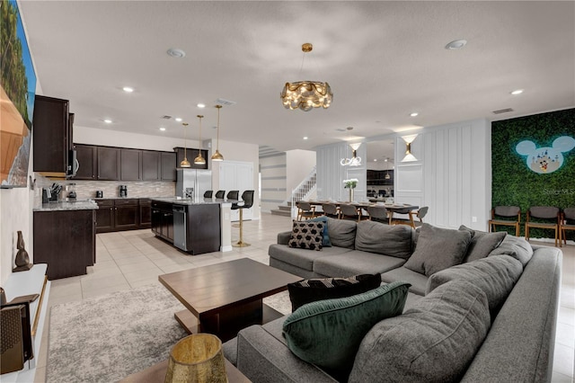 living room with light tile patterned floors and a chandelier