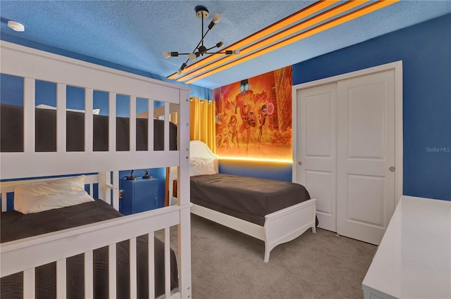 bedroom featuring carpet, a closet, and a textured ceiling