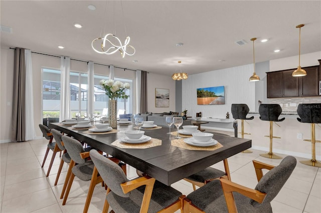 tiled dining area featuring a chandelier