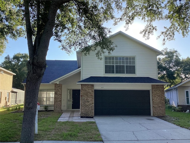 view of property featuring a front yard and a garage