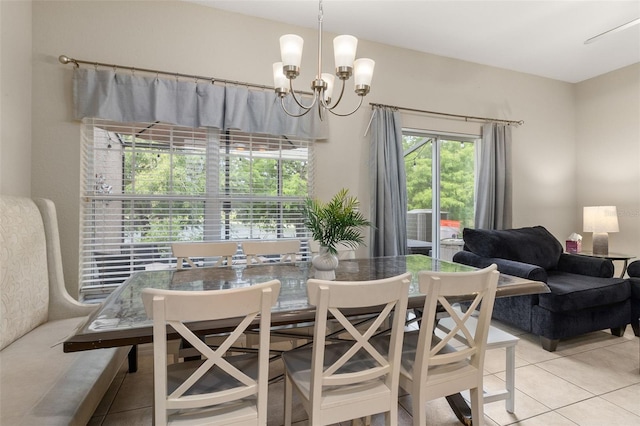 tiled dining room with an inviting chandelier