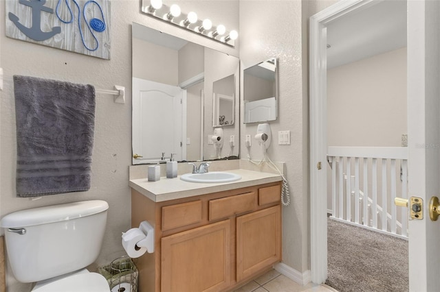 bathroom with tile patterned flooring, vanity, and toilet