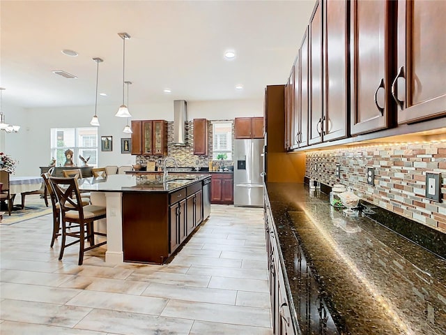 kitchen with pendant lighting, stainless steel appliances, a breakfast bar, and a center island with sink