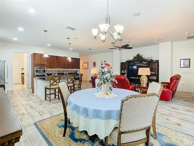 dining room featuring ceiling fan with notable chandelier