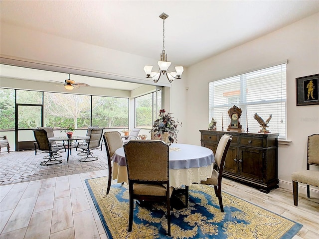 dining area with ceiling fan with notable chandelier and light hardwood / wood-style floors