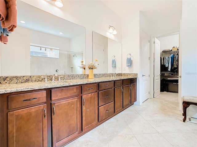 bathroom with tile patterned floors, vanity, and a shower with door