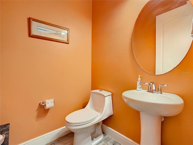 bathroom featuring sink, toilet, and tile patterned flooring