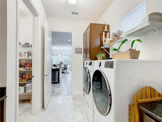 washroom featuring separate washer and dryer, light tile patterned floors, and cabinets