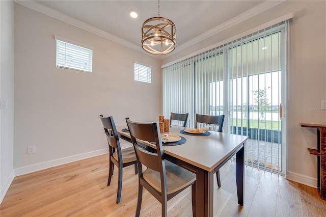 dining room featuring crown molding, light hardwood / wood-style flooring, and a chandelier