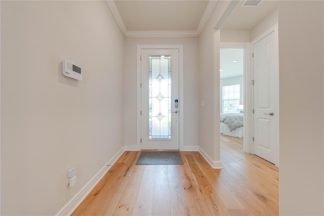 foyer with light hardwood / wood-style floors and crown molding