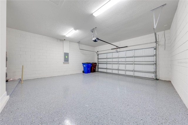 garage with a garage door opener and electric panel