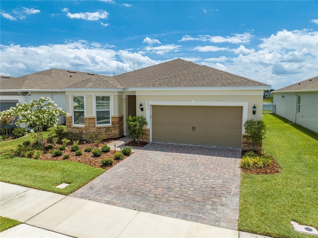 single story home with a garage and a front lawn