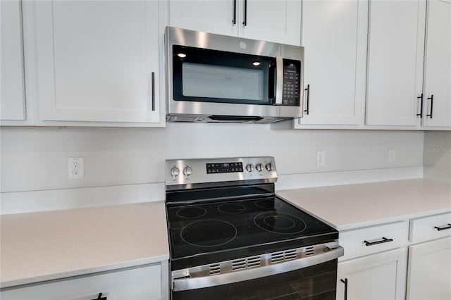 kitchen with stainless steel appliances and white cabinets