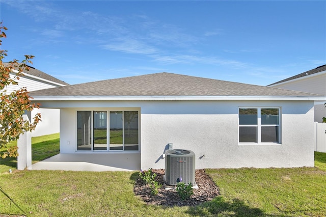 rear view of property featuring a yard, a patio, and central air condition unit