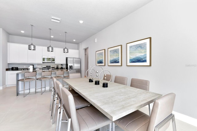 dining room featuring a textured ceiling and light tile patterned flooring