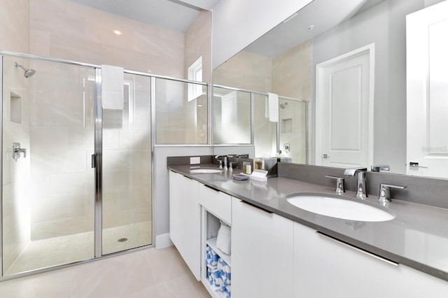 bathroom with a shower with door, vanity, and tile patterned flooring