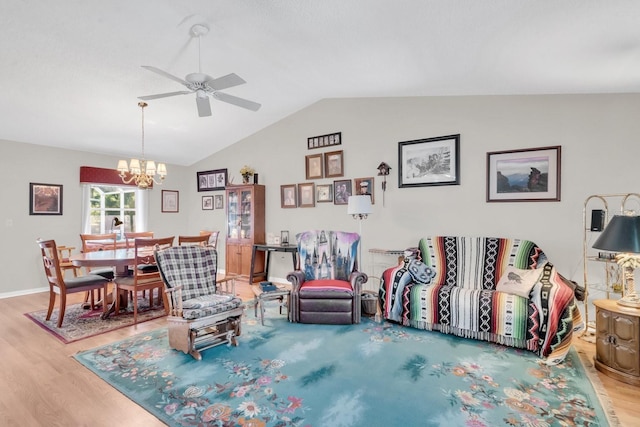 living room featuring hardwood / wood-style flooring, ceiling fan with notable chandelier, and vaulted ceiling