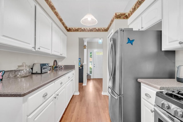 kitchen featuring stove, stainless steel fridge, pendant lighting, light hardwood / wood-style flooring, and white cabinets