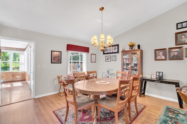 dining area featuring a wealth of natural light, a notable chandelier, and light wood-type flooring