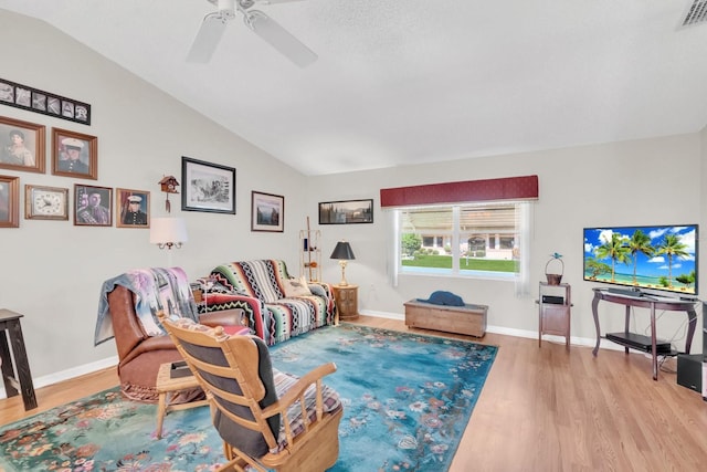 living room featuring ceiling fan, lofted ceiling, and light wood-type flooring