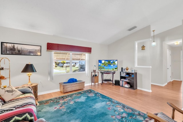 living room featuring hardwood / wood-style floors and vaulted ceiling