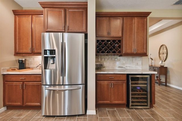 kitchen featuring decorative backsplash, stainless steel fridge with ice dispenser, wine cooler, and wood-type flooring