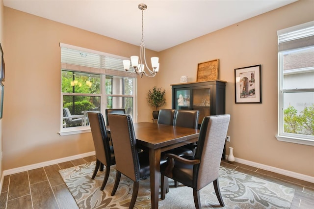 dining area with dark wood-type flooring and an inviting chandelier