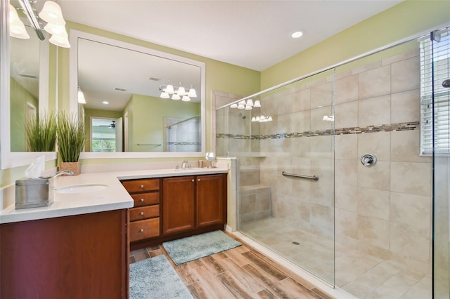 bathroom with plenty of natural light, wood-type flooring, walk in shower, and vanity