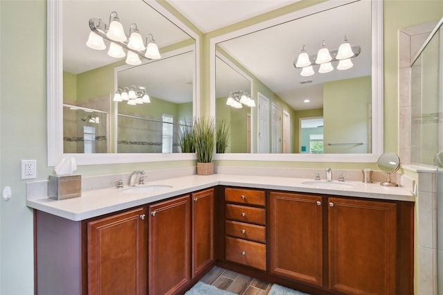 bathroom featuring wood-type flooring, vanity, a wealth of natural light, and a shower with shower door