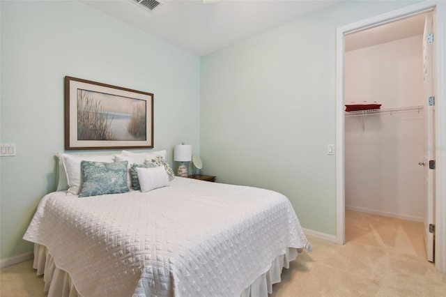 carpeted bedroom with a walk in closet and a closet