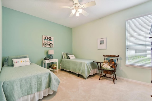 bedroom with ceiling fan and light carpet