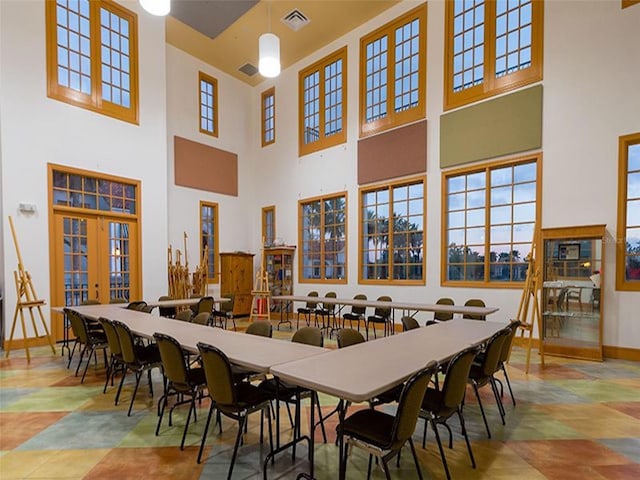 dining area featuring a towering ceiling