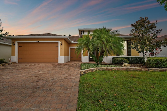 view of front facade featuring a garage and a yard