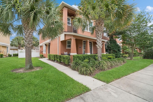 view of front of house with a balcony and a front lawn