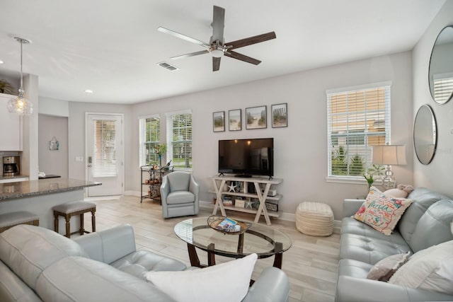 living room with ceiling fan and light hardwood / wood-style floors