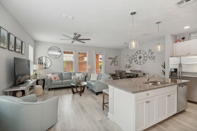 kitchen with sink, white cabinets, an island with sink, and appliances with stainless steel finishes